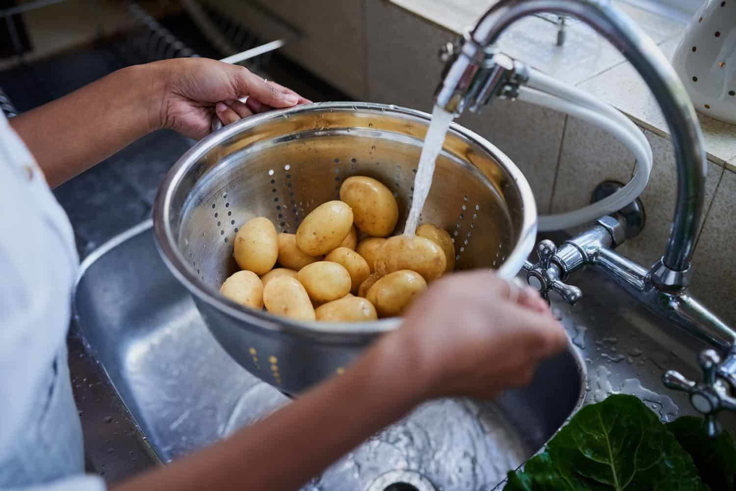 一个女人在家里的厨房水槽里冲洗土豆的片段bd手机下载