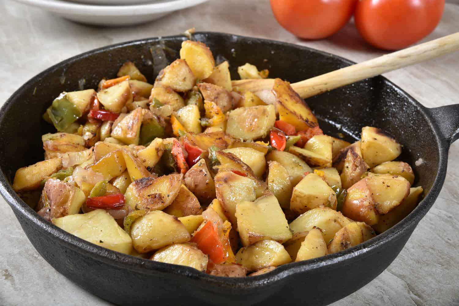 美食在铸铁煎锅用烤土豆,青椒和洋葱