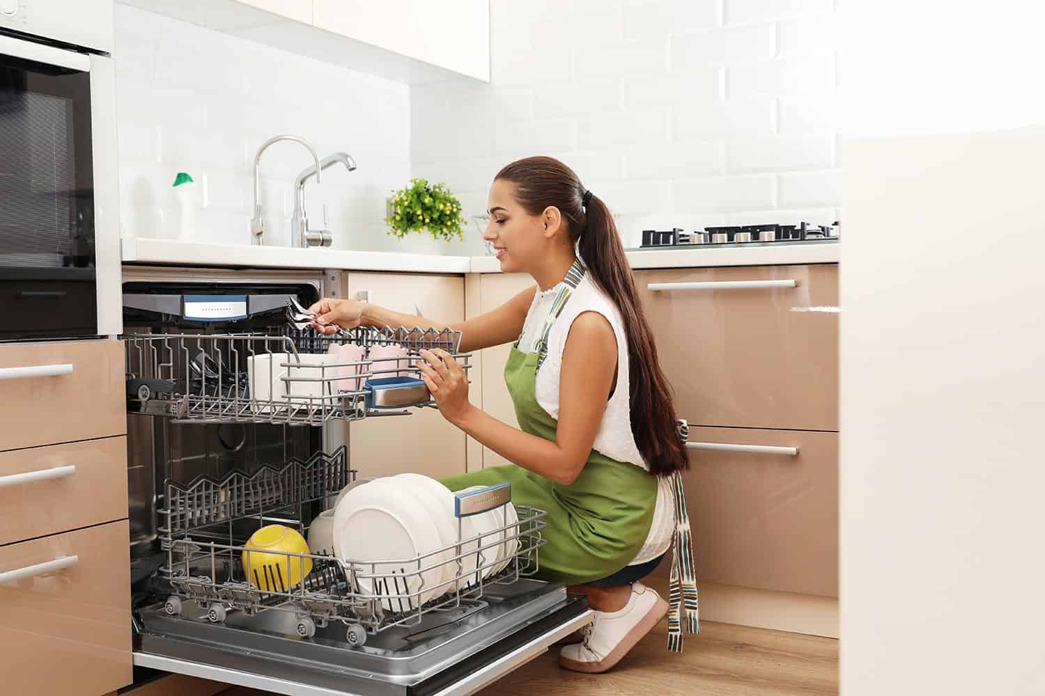 美丽的年轻女子加载洗碗机的厨房bd手机下载