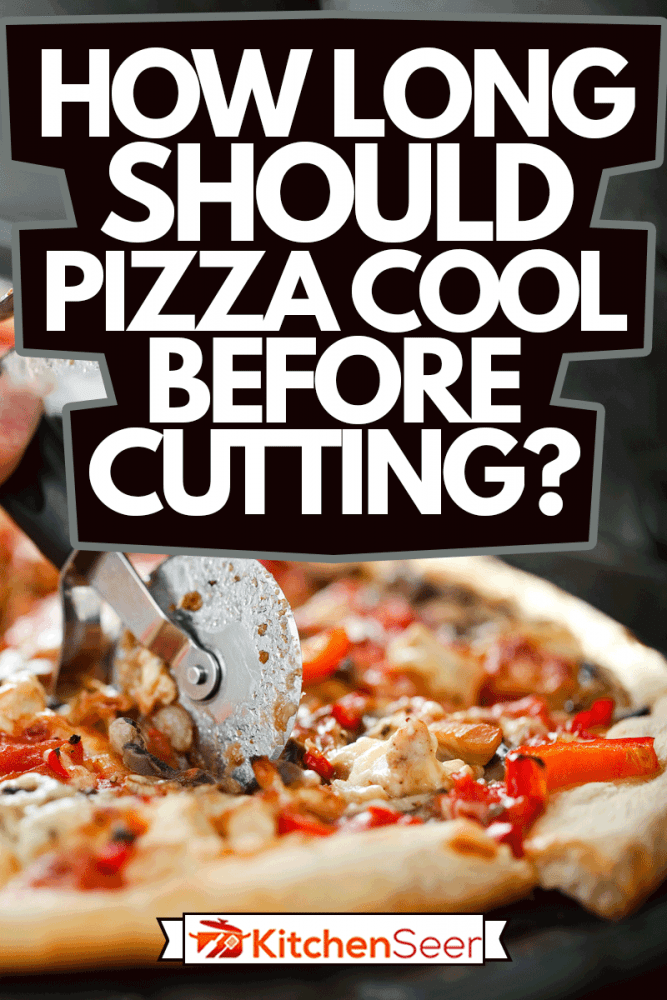 大厨用切刀切成块的切菜板上的披萨特写，披萨在切之前应该冷却多久?