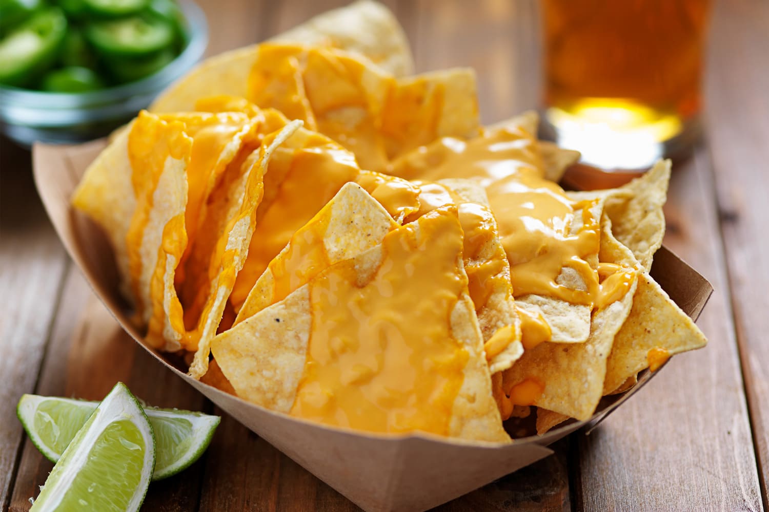 nachos and cheese in tray with beer shot close up