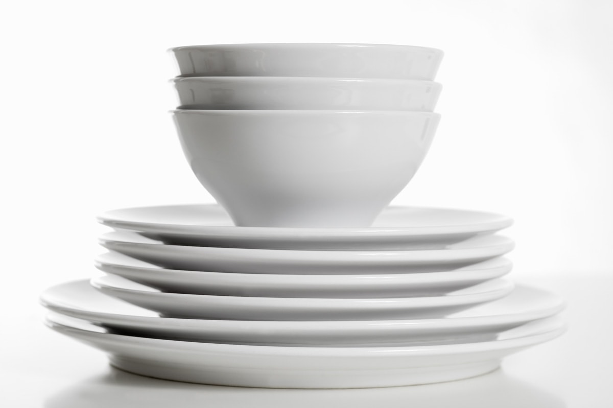 一堆白色的盘子和碗。
